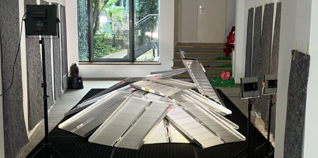 Ein Haufen von klappbaren Aluminium-Rampen wird von Strahlern angeleuchtet.